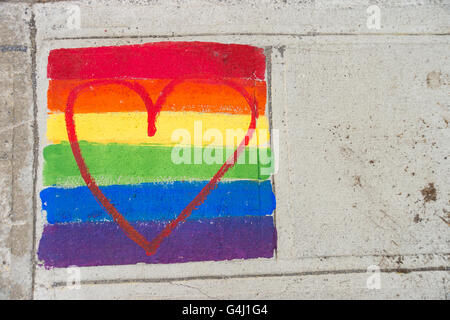 Gay-drapeau arc-en-ciel et coeur rouge peint sur un trottoir Banque D'Images