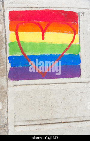 Gay-drapeau arc-en-ciel et coeur rouge peint sur un trottoir Banque D'Images