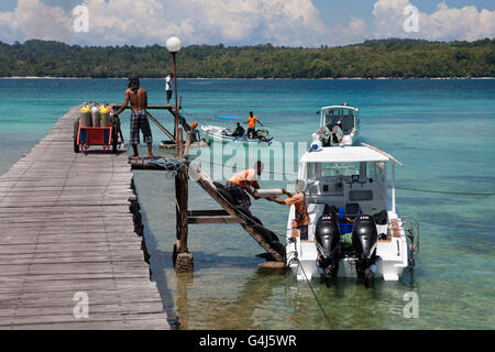 Les réservoirs de plongée chargement sur bateau de plongée, Ambon, Moluques, Indonésie Banque D'Images
