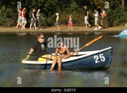 Un couple se détend dans un bateau à rames sur le Serpentine, à Hyde Park, alors que la vague de chaleur va se poursuivre bien la semaine prochaine dans certaines parties de la Grande-Bretagne, après un week-end de températures record. Banque D'Images