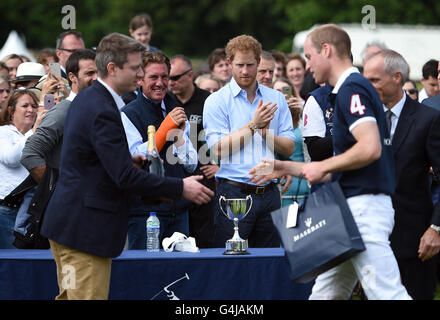 Le prince Harry (centre) se réjouit que son frère le duc de Cambridge reçoit un sac-cadeau, après que son équipe a gagné un match de polo de bienfaisance à Beaufort Polo Club à Tetbury, Gloucestershire. Banque D'Images