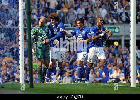 Tim Howard, gardien de but d'Everton (à gauche), est félicité par les coéquipiers après Sauver une pénalité de Dirk Kuyt de Liverpool Banque D'Images