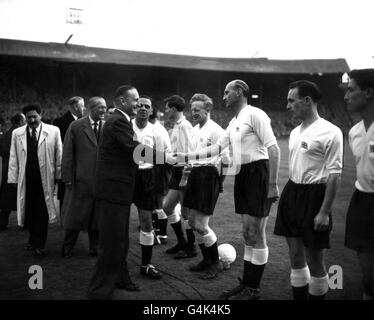 Lord Burghley, ancien champion olympique de course à la lance, serre la main avec le vétéran Bob Hardisty (évêque Auckland) lorsqu'il rencontre l'équipe de Grande-Bretagne avant le match de qualification des Jeux Olympiques contre la Bulgarie à l'Empire Stadium, Wembley.L'équipe britannique s'est battue avec galoper pour un tirage au sort de 3-3, mais n'a pas réussi à se qualifier. Banque D'Images