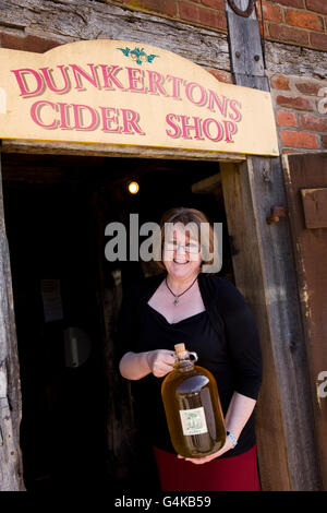 UK, Herefordshire, Pembridge, Dunkerton's Mill, Penny Brown holding demijohn de Perry Banque D'Images