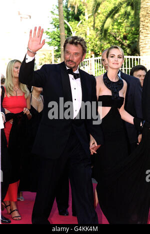 Le chanteur français Johnny Hallyday et son épouse, le modèle Laetitia, arrivent pour la première du film "un mari idéal" à Cannes, en France, lors du 52e Festival international du film de Cannes. Banque D'Images