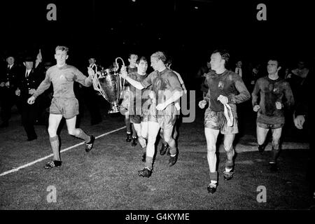 PA NEWS PHOTO 29/5/68 LES JOUEURS DE MANCHESTER UNITED ALEX STEPNEY ET BOBBY CHARLTON, AVEC TONY DUNNE PRÊT LA MAIN ENTRE EUX, PORTENT LA COUPE EUROPÉENNE APRÈS QUE UNITED AIT GAGNÉ LA FINALE AU STADE WEMBLEY, LONDRES, EN BATTANT BENFICA DU PORTUGAL 4-1 DANS LA FINALE. Banque D'Images