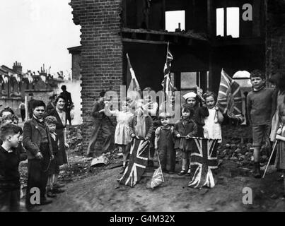 Les jeunes résidents de Londres célèbrent le VE-Day (jour de la victoire en Europe) marquant la fin de la guerre en Europe, au milieu des ruines de leur maison à Battersea. Banque D'Images