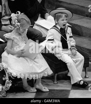 Un bâillement du prince William, fils de 3 ans du prince et de la princesse de Galles, lors de la cérémonie de mariage de Sarah Ferguson et du duc d'York à l'abbaye de Westminster. Son cousin, Laura Fellowes, âgée de 6 ans, est assis à côté du jeune prince. Banque D'Images