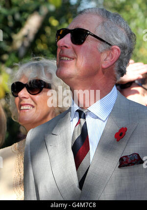 Le prince de Galles et la duchesse de Cornwall regardent une démonstration d'escalade de cococotiers lors d'une visite à la plantation d'épices de Kizimbani à Zanzibar, Tanzanie, Afrique, le troisième jour d'une visite de quatre jours dans le pays. Banque D'Images