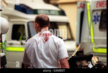 Un policier baigné de sang se rend sur les lieux de la rue Old Compton à Soho, dans le centre de Londres, après un attentat à la bombe. Au moins 2 personnes ont été tuées et 73 personnes ont été blessées par crainte après une explosion sans avertissement au pub Admiral Duncan, un bar gay populaire. Banque D'Images