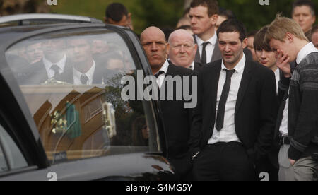 Les amateurs de bourre regardent alors que les cercueils de Bridget Sharkey et de son frère Thomas Sharkey quittent l'église Saint-Joseph à Helensburgh après leurs funérailles. Banque D'Images