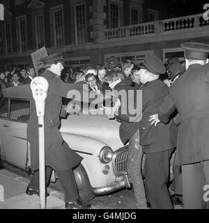 Une voiture dans sa baie de parcmètres est engloutie par une masse de manifestants qui s'empresse contre un cordon de police devant l'ambassade des États-Unis à Grosvenor Square, Londres.Les manifestants, estimés à 2,000 000, protestaient contre le blocus américain de Cuba. Banque D'Images