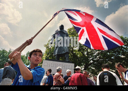 Un jeune garçon agite un drapeau de l'Union devant la statue de Churchill devant le Palais de Westminster à Londres alors qu'un grand groupe d'Albanais du Kosovo se réunissaient pour remercier Tony Blair, le peuple britannique et l'OTAN pour la libération du Kosovo. Banque D'Images