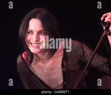 Andrea Corr, du groupe pop irlandais « les Corrs », sourit à la personne qui se déroule sur scène pendant le Glastonbury Festival 1999. Banque D'Images