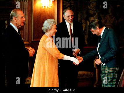 La Reine accueille Sir David Steel, président du Parlement écossais, lors d'une réception au Palais de Holyroodhouse, à Édimbourg, avec le duc d'Édimbourg (à gauche) et le premier ministre Donald Dewar (au centre). * la réception a suivi l'ouverture officielle du premier Parlement écossais en 300 ans plus tôt dans la journée. Banque D'Images