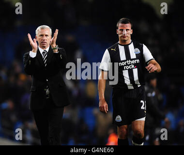 Alan Pardew, directeur de Newcastle United, et Steve Taylor saluent les supporters après leur défaite par Manchester City lors du match de la Barclays Premier League au City of Manchester Stadium, Manchester. Banque D'Images