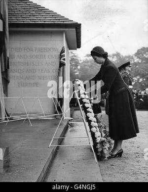 La reine Elizabeth II pose une couronne d'œillets rose pâle, d'orchidées et de nénuphars sur le premier pas menant à l'arche centrale du Mémorial de Runnymede, qu'elle avait dévoilé. Le Mémorial commémore les officiers et les hommes des forces aériennes du Commonwealth qui ont perdu la vie au cours de la Seconde Guerre mondiale et qui n'ont aucune tombe connue. Banque D'Images