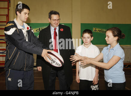 Le ministre du logement gallois Huw Lewis (deuxième à gauche) est photographié avec l'entraîneur Gordon Ferguson (à gauche) et les élèves Matthew Tran (deuxième à droite) et Sophie English (à droite) lors d'une visite à l'école primaire Cadder de Glasgow. Banque D'Images