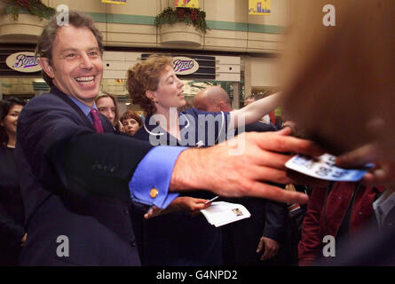 Le Premier ministre britannique Tony Blair distribue des dépliants faisant la promotion du service de ligne téléphonique NHS Direct lors d'une visite à Eldon Square, à Newcastle. Un homme a été arrêté alors que Blair était confronté à des manifestants préoccupés par des politiques dédrées vers la campagne. Banque D'Images