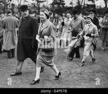 La reine Elizabeth II, suivie de la princesse Margaret qui se promènait jusqu'au paddock aux courses de Sandown Park pour voir le cheval de leur mère, Double Star, courir dans le parc handicap Steeplechase. Banque D'Images