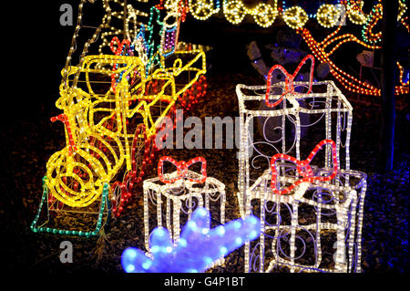 Un train et des cadeaux sont parmi des sculptures de corde lumière assis dans le jardin dans une maison semi-séparée sur Longford Road, Melksham, Wiltshire, car il est éclairé par des lumières et des décorations de Noël que certains ménages au Royaume-Uni entrent dans l'esprit de fête. Banque D'Images