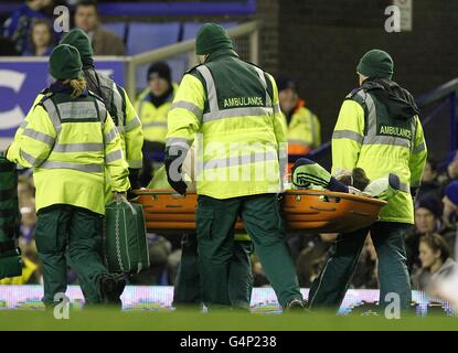 Le gardien de but Thomas Sorensen de la ville de Stoke est étiré du terrain de jeu après avoir subi une blessure à la tête Banque D'Images