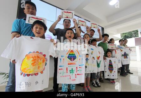 Hefei, Chine, Anhui Province. 19 Juin, 2016. Les enfants et leur père montrer leur main T-shirts pendant un événement pour célébrer le jour de la Fête des pères, qui tombe le troisième dimanche de juin, à Hefei, Chine de l'est l'Anhui Province, le 19 juin 2016. © Chen Sanhu/Xinhua/Alamy Live News Banque D'Images