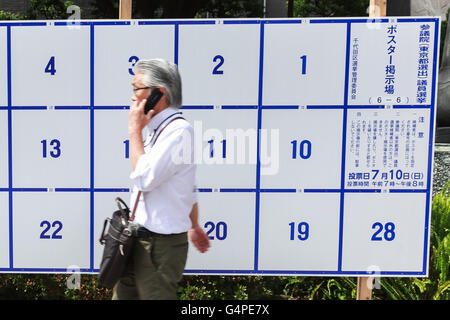 Un homme passe devant une affiche érigée spécialement pour les publicités électorales des candidats prêts à tenir des affiches pour la Juillet Chambre des conseillers élections sur afficher dans les rues de Tokyo le 20 juin 2016, au Japon. L'avant du 10 juillet les candidats sondage rendez-vous dans les rues de mettre en place les affiches de la campagne, faisant des discours et la tenue des rassemblements de présenter leurs politiques. Cette année, les partis politiques ciblent les jeunes électeurs, âgés de 18 et 19 ans, qui sont autorisés à voter pour la première fois. © Rodrigo Reyes Marin/AFLO/Alamy Live News Banque D'Images