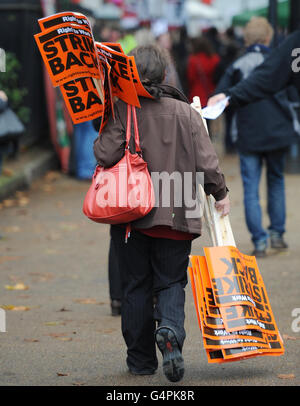 Un membre du public porte des pancartes avant une marche par les travailleurs du secteur public dans le centre de Londres, alors que les travailleurs autour du Royaume-Uni sont l'étape la plus importante grève générale depuis des décennies aujourd'hui dans une rangée sur les retraites. Banque D'Images