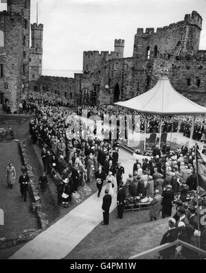 La reine Elizabeth II, suivie par le duc d'Édimbourg, à l'intérieur des murs du château de Caernarfon, dans le cadre de sa visite de deux jours au Couronnement du pays de Galles.On croit que la Reine est la première reine régnante à entrer dans le château de Caernarfon depuis que sa construction a été commencée par le roi Edward II Banque D'Images