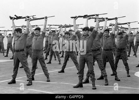 LA GUERRE DES MALOUINES: Membres d'UNE compagnie : 40 Royal Marine Commandos, en gardant à l'assiette sur le pont du porteur HMS Hermes alors qu'elle se dirige vers le sud pour les îles Falkland avec la force opérationnelle navale britannique. Banque D'Images