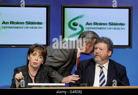 Mark Costigan, attaché de presse (au centre), parle au ministre des soins primaires et de la Stratégie nationale antidrogue, Roisin Shortall, et au ministre de la Santé, le Dr James Reilly, qui donnent leurs réactions au budget d'aujourd'hui lors d'une conférence de presse dans les bâtiments gouvernementaux de Dublin, en tant que Brendan Howlin, ministre des dépenses publiques et de la réforme, Détailler la première moitié du budget de 2012 avec l'évaluation sans équivoque que la prise d'impôt du pays a diminué d'un tiers en trois ans. Banque D'Images