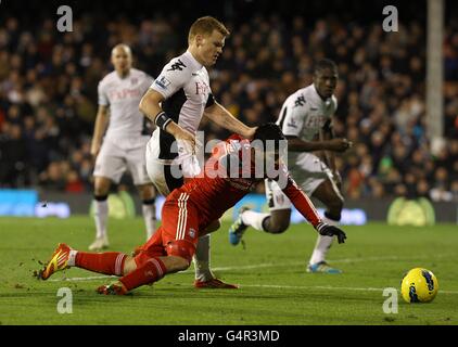 Football - Barclays Premier League - Fulham / Liverpool - Craven Cottage.Luis Suarez de Liverpool descend dans la zone de pénalité sous le défi de John Arne Riise de Fulham Banque D'Images