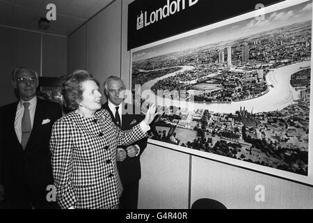 Le Premier ministre Margaret Thatcher discute de l'impression d'un artiste sur le développement futur dans la région des docklands avec Chris Benson, président de la London Docklands Development Corporation, à son siège social à Londres. Aussi images (l) est Denis Thatcher. Banque D'Images