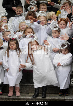 Les enfants habillés comme des anges, de la pépinière St Josephs, chantant des chants de Noël comme le berceau animal vivant traditionnel, fourni par l'Association des agriculteurs irlandais, ouvre au Mansion House à Dublin. Banque D'Images