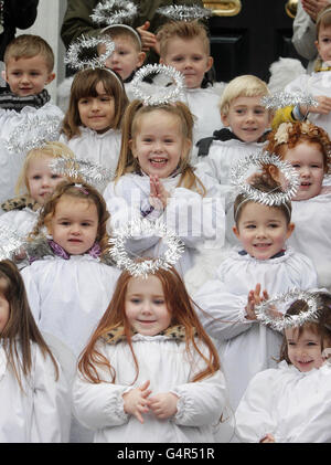 Des enfants habillés comme des anges de la pépinière St Joseph chantant des chants de Noël, comme le berceau animal vivant traditionnel, fourni par l'Association des agriculteurs irlandais, ouvre à la Maison de la maison à Dublin. Banque D'Images