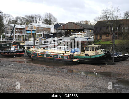 Les bateaux sur la Tamise à Twickenham sont laissés en hauteur et secs après les travaux prévus sur les déversoirs à proximité à Richmond ont laissé le lit de la rivière exposé. Banque D'Images