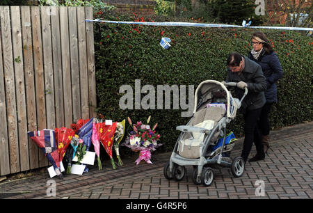 Les résidents passent sous un ruban de police sur les lieux près d'une maison à Pudsey, Leeds, où quatre corps ont été découverts en fin d'après-midi de dimanche. Banque D'Images