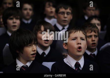 Des écoliers de l'école catholique Leeson St. Chantant des chants de chants à l'extérieur de l'église Sainte-Anne à Dublin, pendant l'appel annuel de Noël de Père Noël noir. Banque D'Images