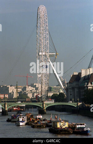 Le London Eye de British Airways, d'une capacité de 1,500 tonnes, est entièrement en position verticale après que son cadre a été soulevé avec succès sur les rives de la Tamise.* la structure de 450 pieds, qui se trouve sur la South Bank de Londres, presque en face du Parlement, sera maintenant équipée de 32 capsules de visualisation spéciales qui transporteront les visiteurs au-dessus de la capitale.Une porte-parole de BA a déclaré que les travaux commenceraient à installer les capsules spécialement conçues sur la roue d'observation. Banque D'Images