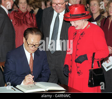 La Reine sourit alors que le président chinois Jiang Zemin signe sa signature dans le livre des visiteurs lors d'une visite au British Museum, où il a ouvert une exposition intitulée Gilded Dragons, a enterré le Trésor de l'âge d'or de la Chine. Banque D'Images