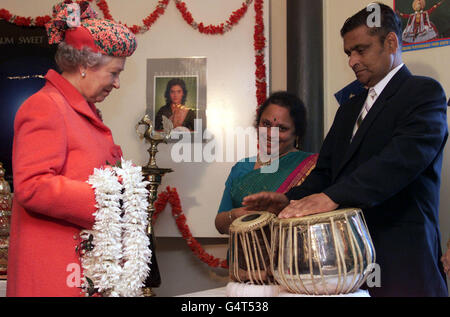 La reine Elizabeth ll de Grande-Bretagne regarde un batteur hindou lors d'une exposition au Dudson Center de Stoke on Trent. Au cours de sa visite, la Reine a également rencontré des membres de l'Orchestre de Halle et visité l'Université Keele. Banque D'Images