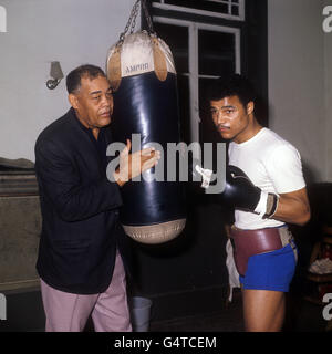 Joe Louis, ancien champion américain de boxe poids lourd, aide le combattant britannique poids lourd John Conteh dans la salle de sport. Le Liverpudlian se prépare à combattre Dave Matthews en quelques jours à Nottingham. Banque D'Images