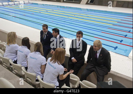 Le Premier ministre David Cameron (à gauche) et le maire de Londres Boris Johnson (à droite), ainsi que Lord Sebastian COE (deuxième à gauche) et le ministre de la Culture et des Sports Jeremy Hunt (deuxième à droite), parlent au personnel lorsqu'ils visitent le Centre aquatique olympique de Londres. Banque D'Images