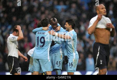 Mario Balotelli (au centre) de Manchester City célèbre le but gagnant de la zone de pénalité avec des copains, alors que les joueurs de Tottenham Hotspur sont découragés Banque D'Images