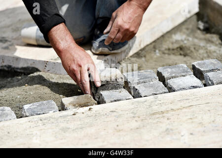 Plus de détails avec les mains d'un maçon travaillant avec cobblestone Banque D'Images