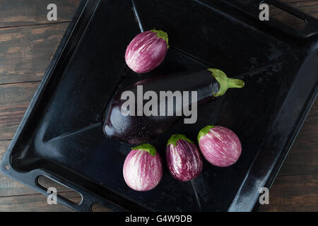 Aubergines humide - la magie noire, et violet aubergine à rayures dans le style rustique de cuisson. Vue de dessus with copy space Banque D'Images