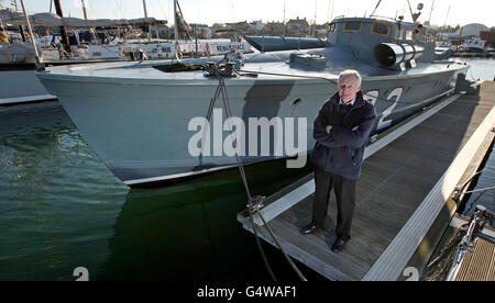 Richard Basey se tient le long du Motor Torpedo Boat 102, attaché à Oulton Broad, Lowestoft, Suffolk. Banque D'Images