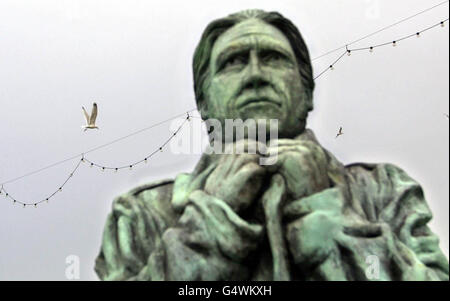 La statue du fondateur de la Royal National Lifeboat institution Sir William Hillary, à Douglas sur l'île de Man, donne sur la mer d'Irlande, où les équipes de sauvetage commencent la tâche d'élever le bateau de pêche Solway Harvester, qui a coulé le 11/01/2000. Banque D'Images