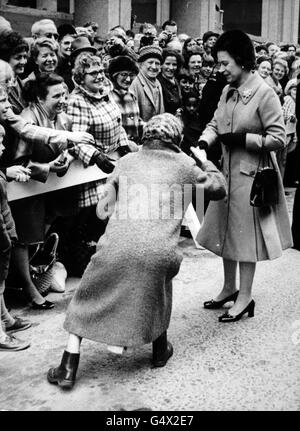 *numérisation basse résolution à partir de la presse, haute résolution disponible sur demande* UN membre de la foule curtseys pour la reine Elizabeth II lors d'une visite à Birmingham Banque D'Images